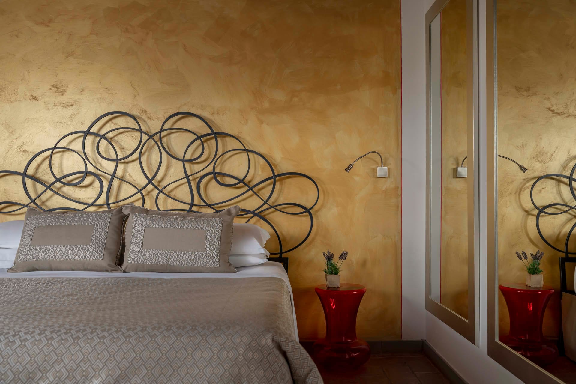 Detail des Doppelbettes mit Schmiedeeisen-Kopfteil im Deluxe-Zimmer