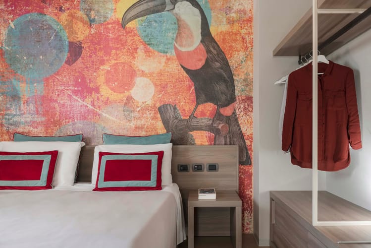 Detail des Doppelbettes und Kleiderschranks im Gartenzimmer des Casolare Terre Rosse