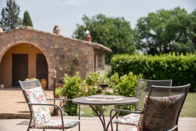 Dettaglio giardino esterno con tavolino e calice di vino