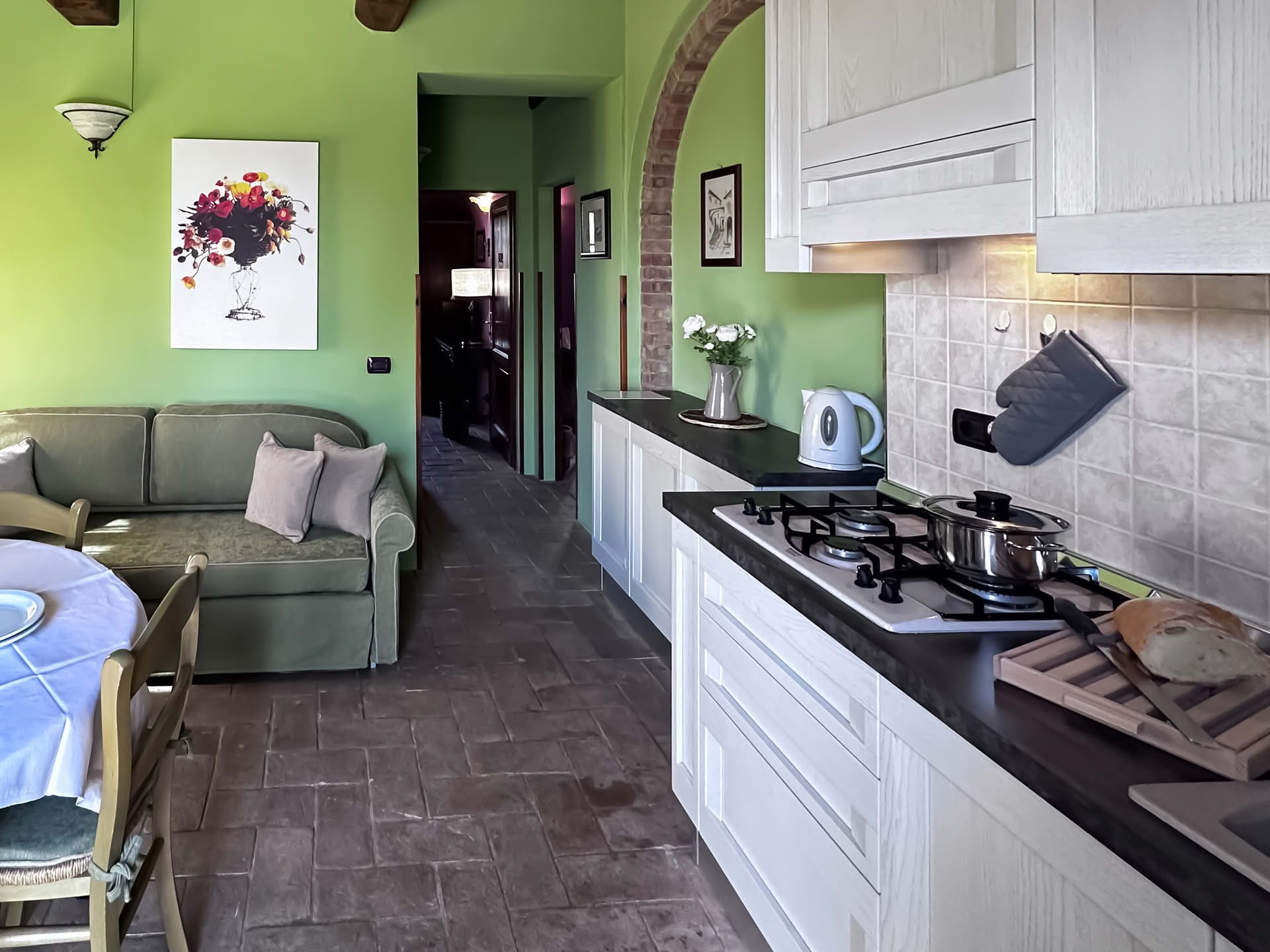 Wohnküche mit Esstisch und Sofa im Quercia-Apartment