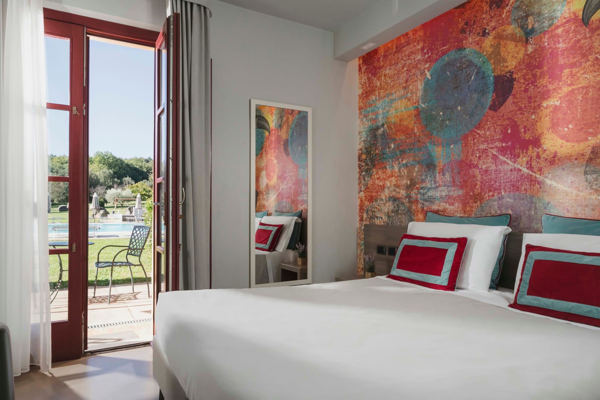 Detail des Gartenzimmers mit großer Terrassentür und Doppelbett im Casolare Terre Rosse