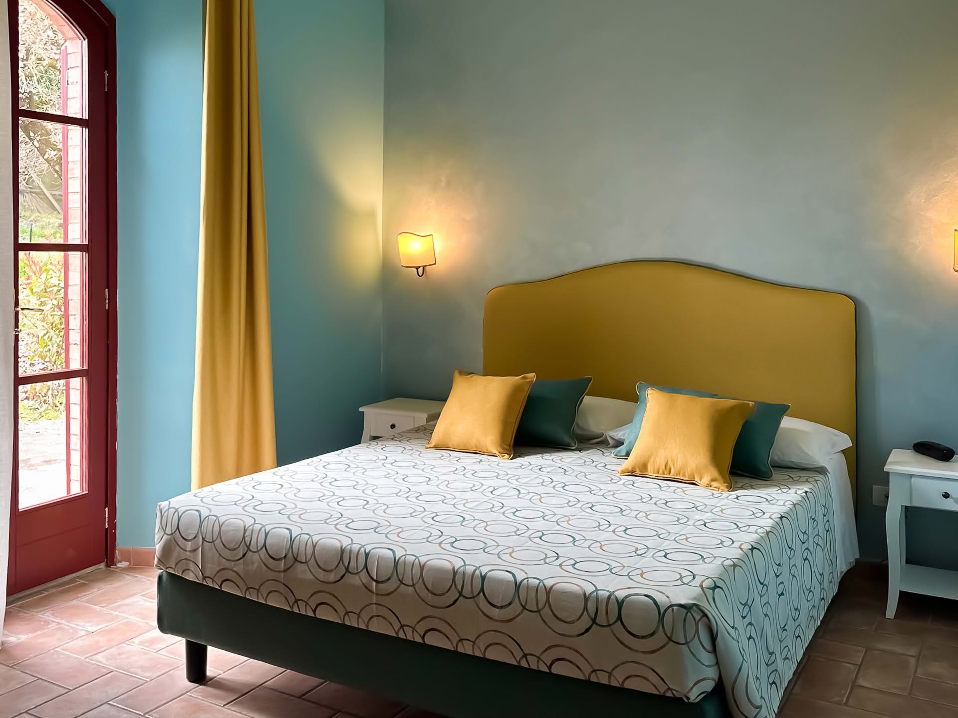 Doppelzimmer mit Terrassentür mit Blick auf den Garten im Olivo-Apartment